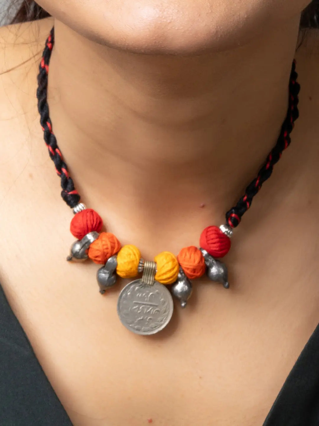 Afghani pendant necklace with colorful beads and metallic coin charm on braided black cord