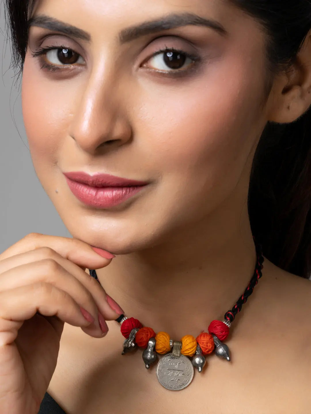Close-up of woman wearing traditional Afghani pendant necklace with red and orange beads