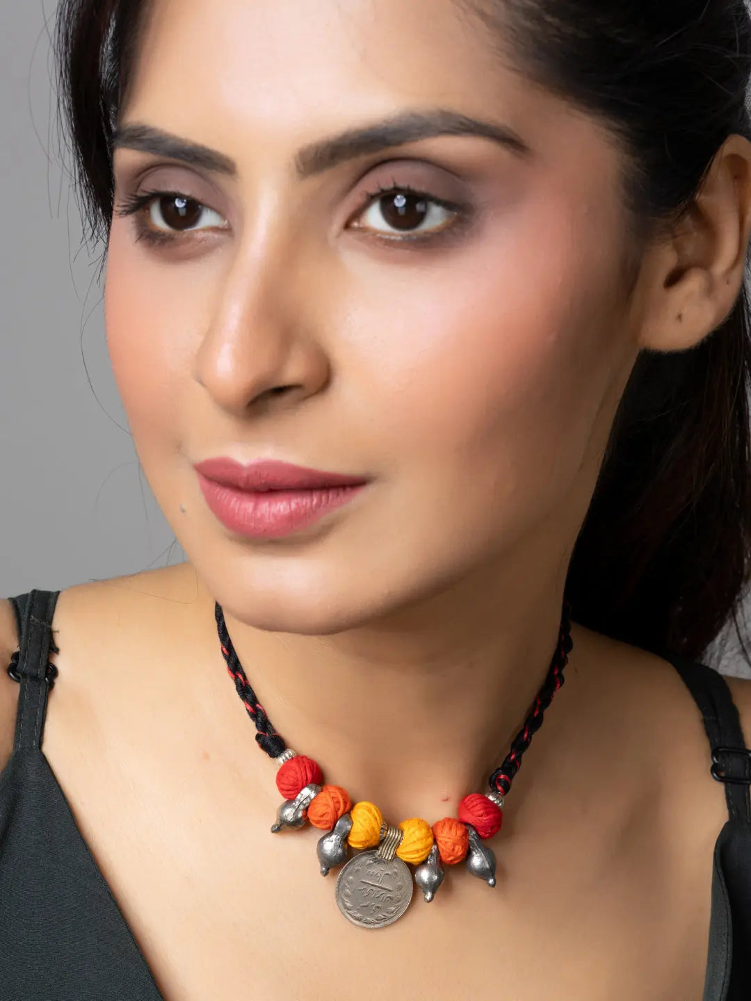Woman wearing colorful Afghani pendant necklace with red, orange, and yellow beads and silver accents