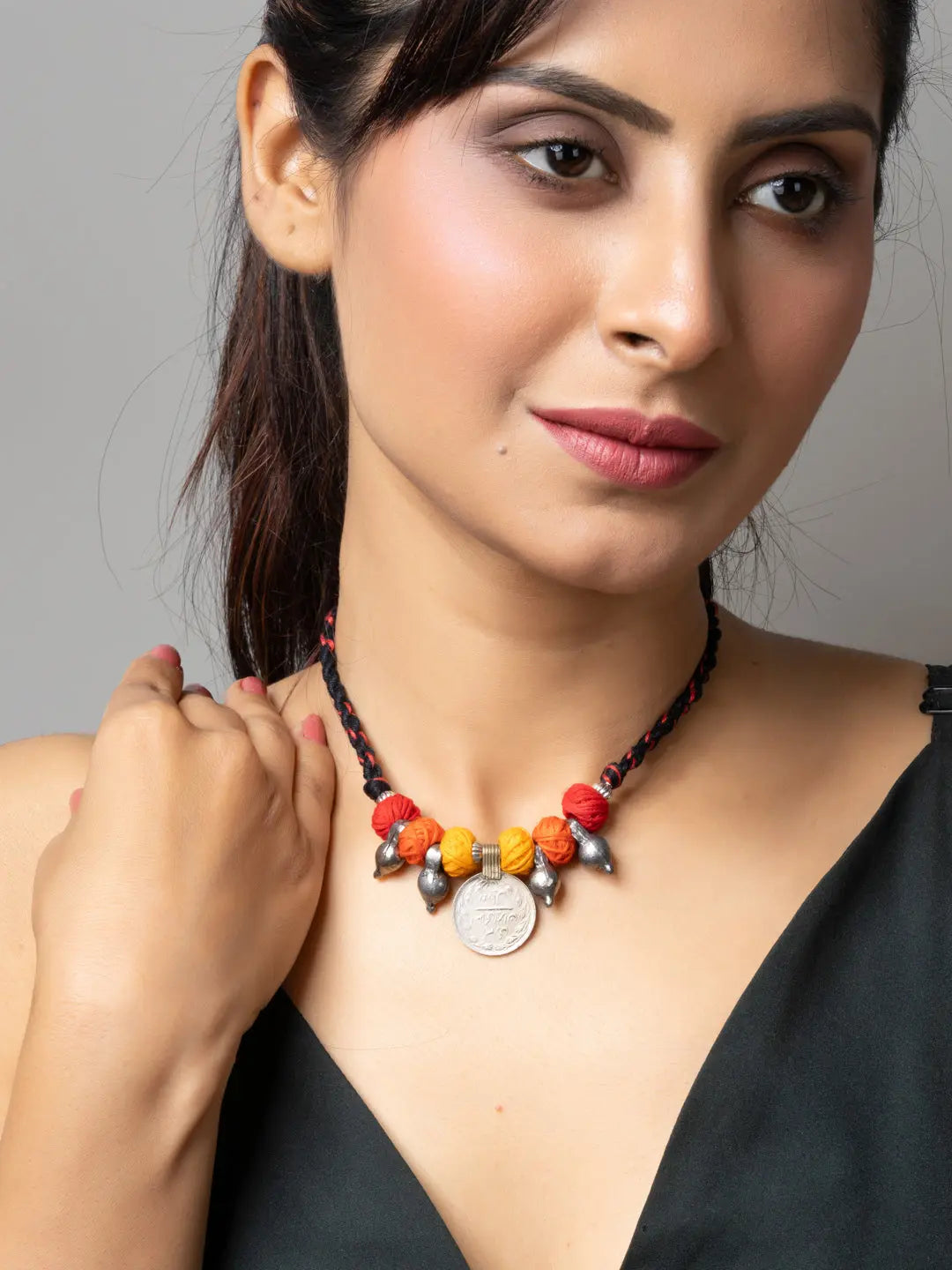 Woman wearing colorful afghani pendant necklace with red and yellow beads and silver accents