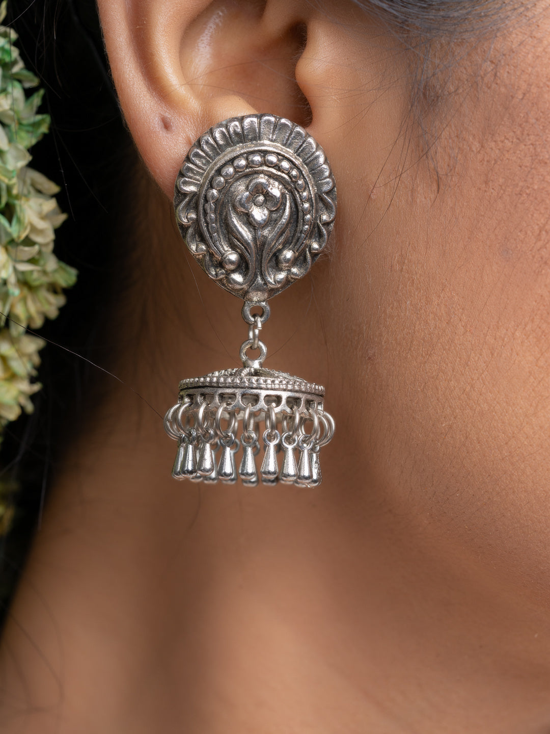 Oxidised silver jhumka earrings with intricate detailing worn on ear for traditional style