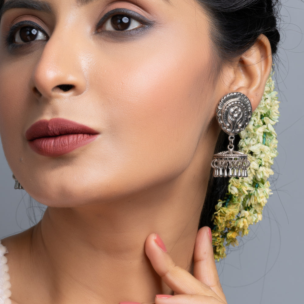 Oxidised silver jhumka earrings worn by woman with floral hair accessories from LOOK AND ADORN