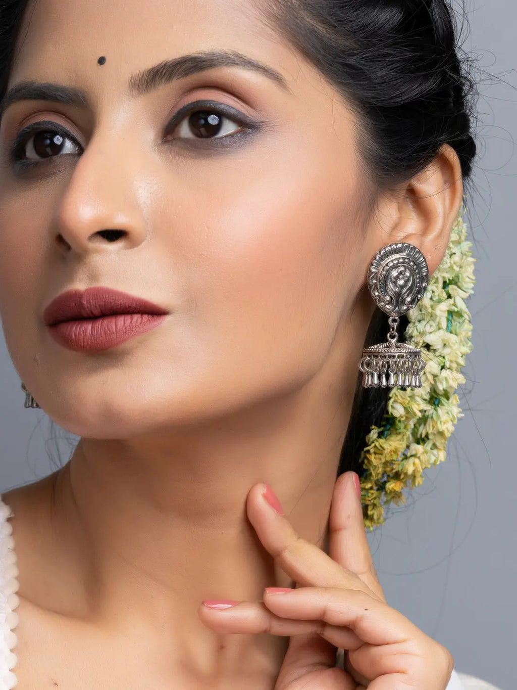 Oxidised silver jhumka earrings worn by woman with floral hair accessories from LOOK AND ADORN