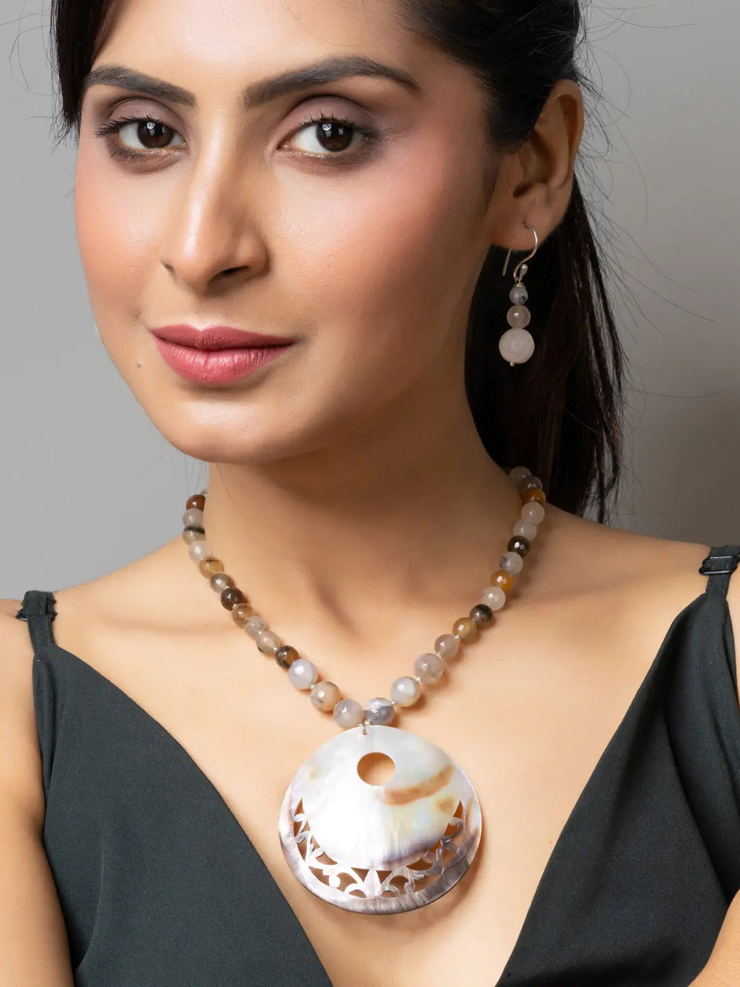 Woman wearing LOOK AND ADORN handmade Mother of Pearl Pendant necklace and matching earrings