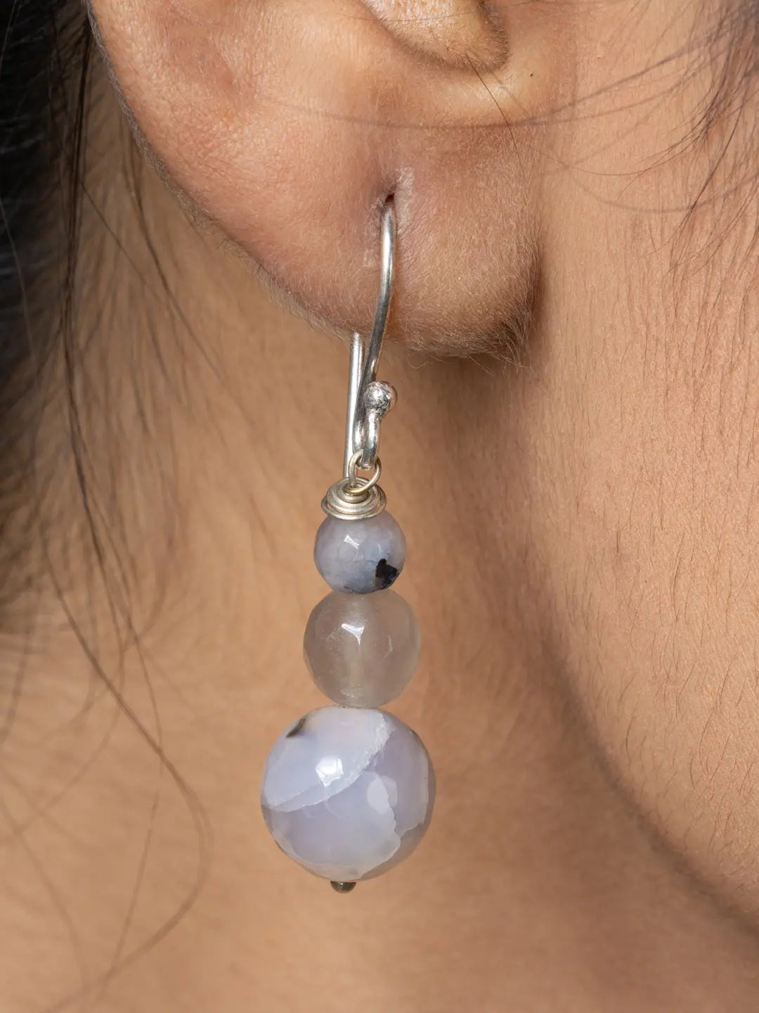 Close-up of handmade Mother of Pearl Pendant earring with silver hook on ear