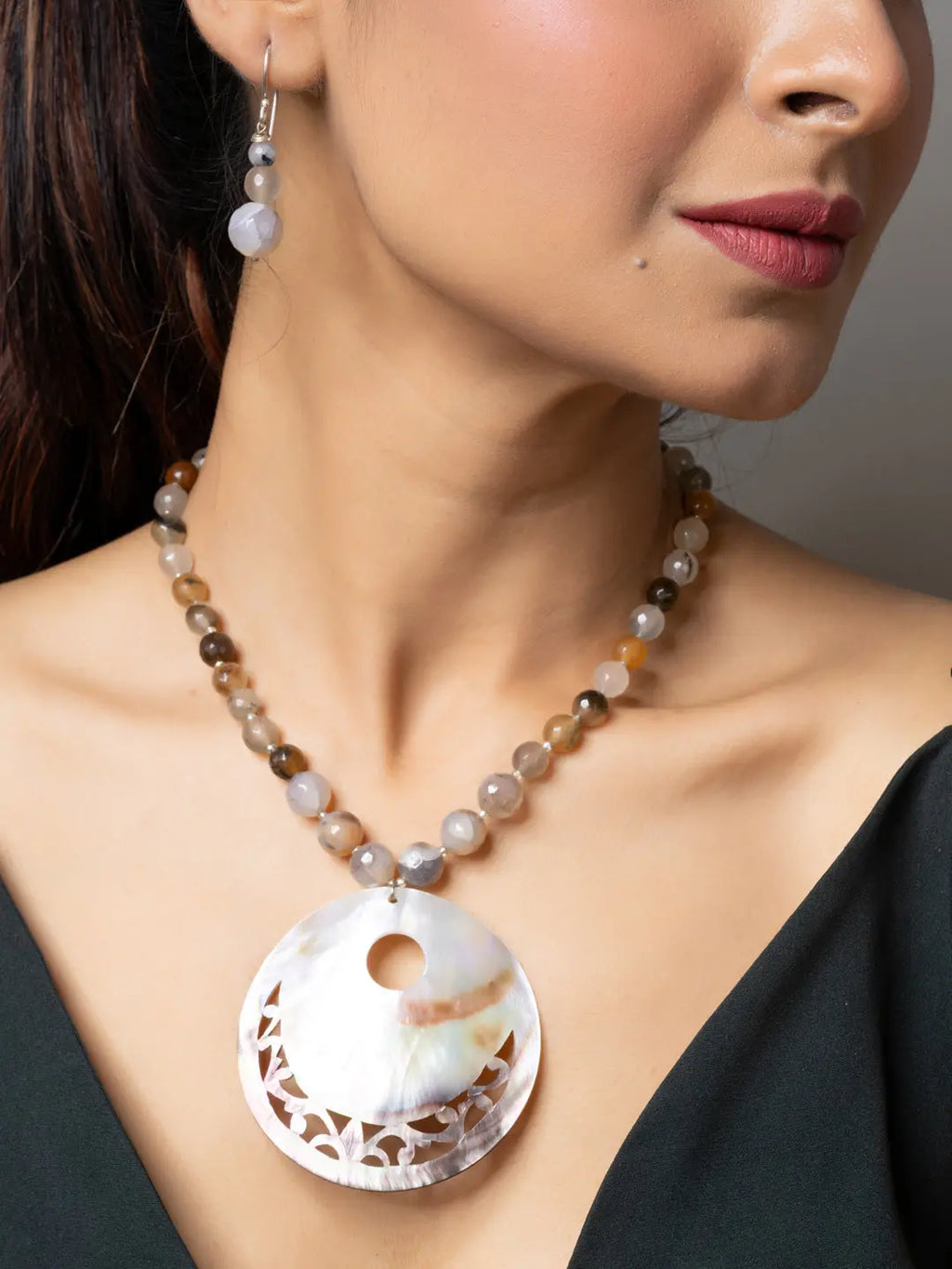 Handmade Mother of Pearl Pendant necklace with beaded chain worn by woman with matching earrings