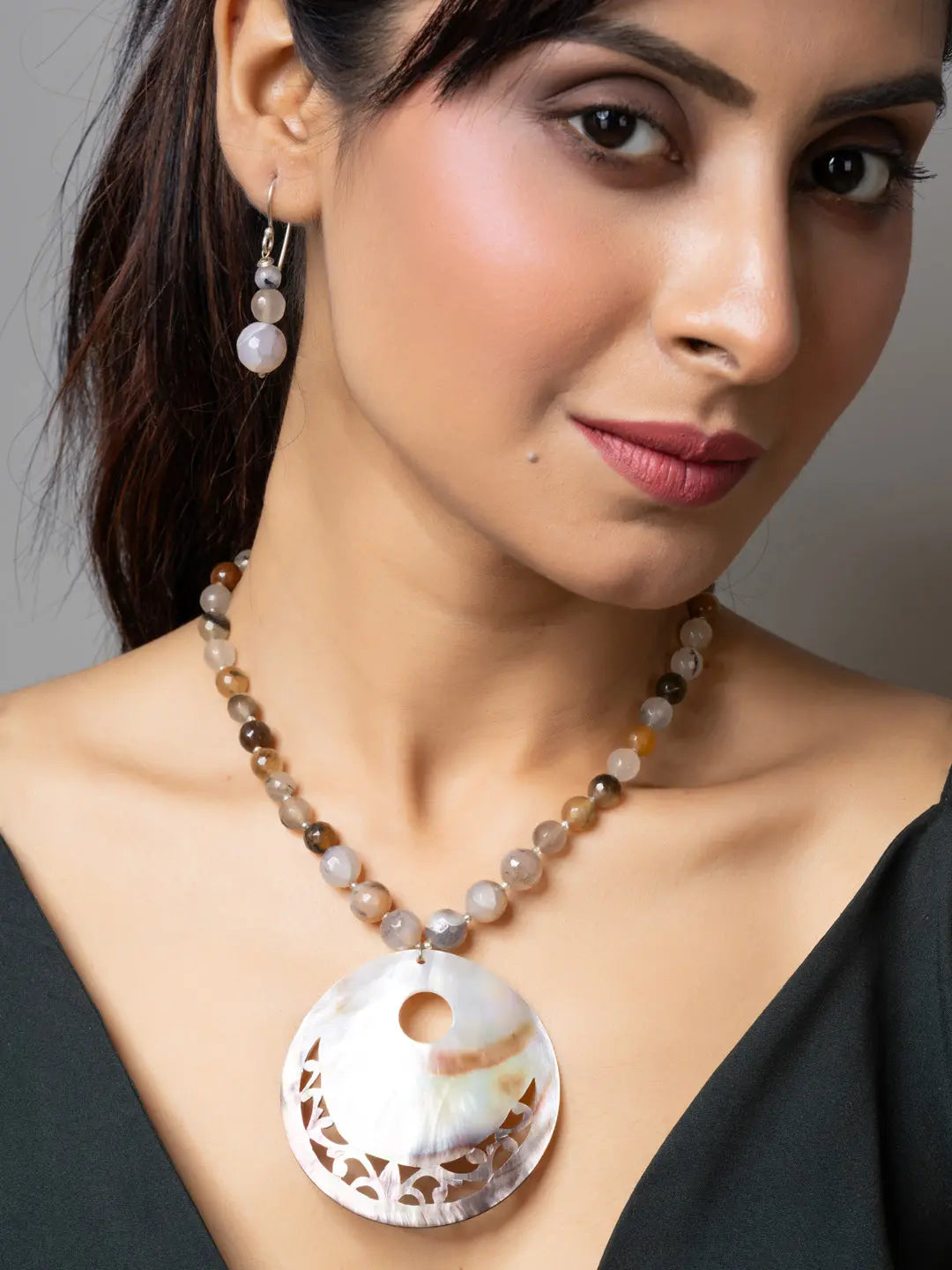 Woman wearing handmade Mother of Pearl Pendant necklace and matching earrings from LOOK AND ADORN