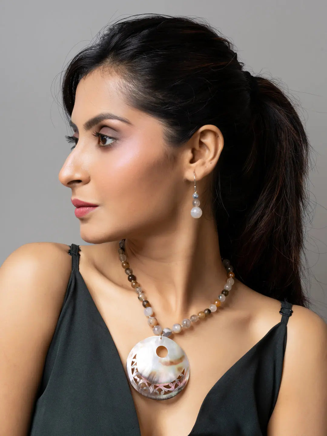 Woman wearing handmade Mother of Pearl Pendant necklace and matching earrings by LOOK AND ADORN
