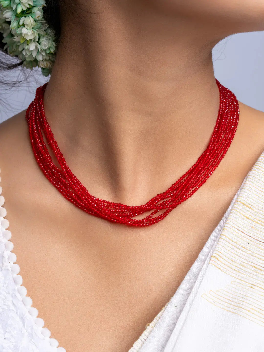 Handmade multi-strand red crystal necklace from LOOK AND ADORN worn on a woman's neck