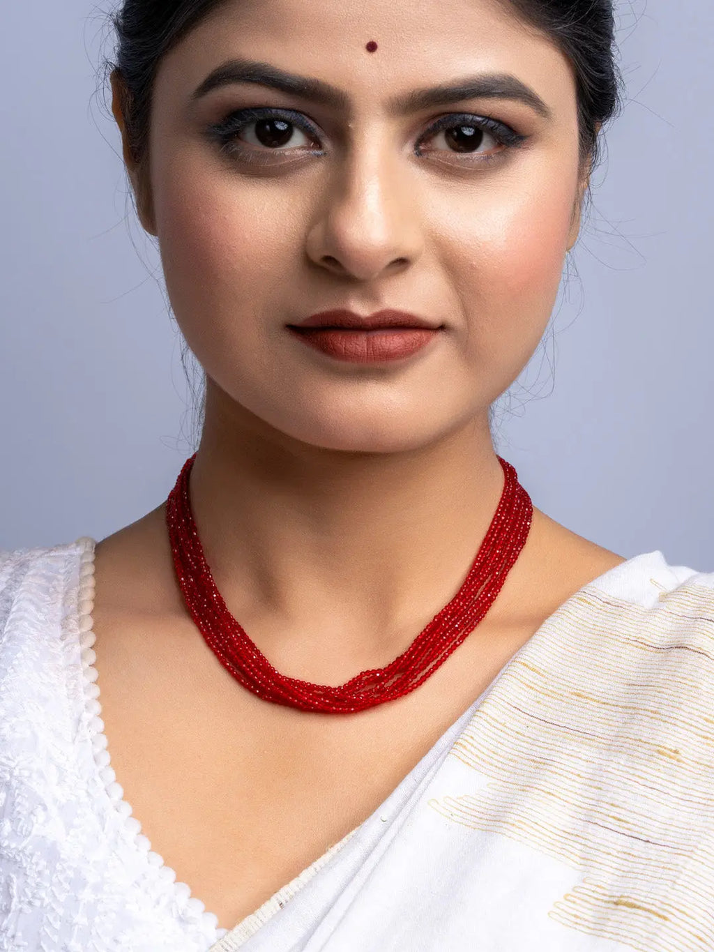 Handmade red crystal necklace worn by woman in white traditional attire by LOOK AND ADORN