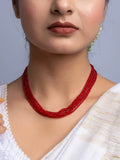 Handmade red crystal necklace with multiple strands worn by woman in white outfit